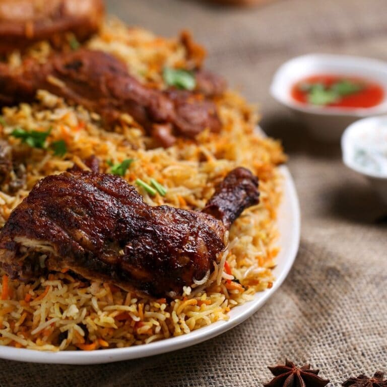 Square image of chicken tiki masala on a white plate.