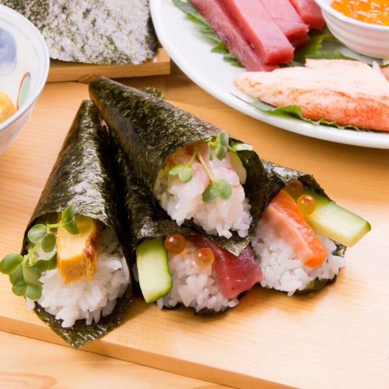 Sushi roll vs hand roll information illustrated with delicious hand rolls served on wooden cutting board.