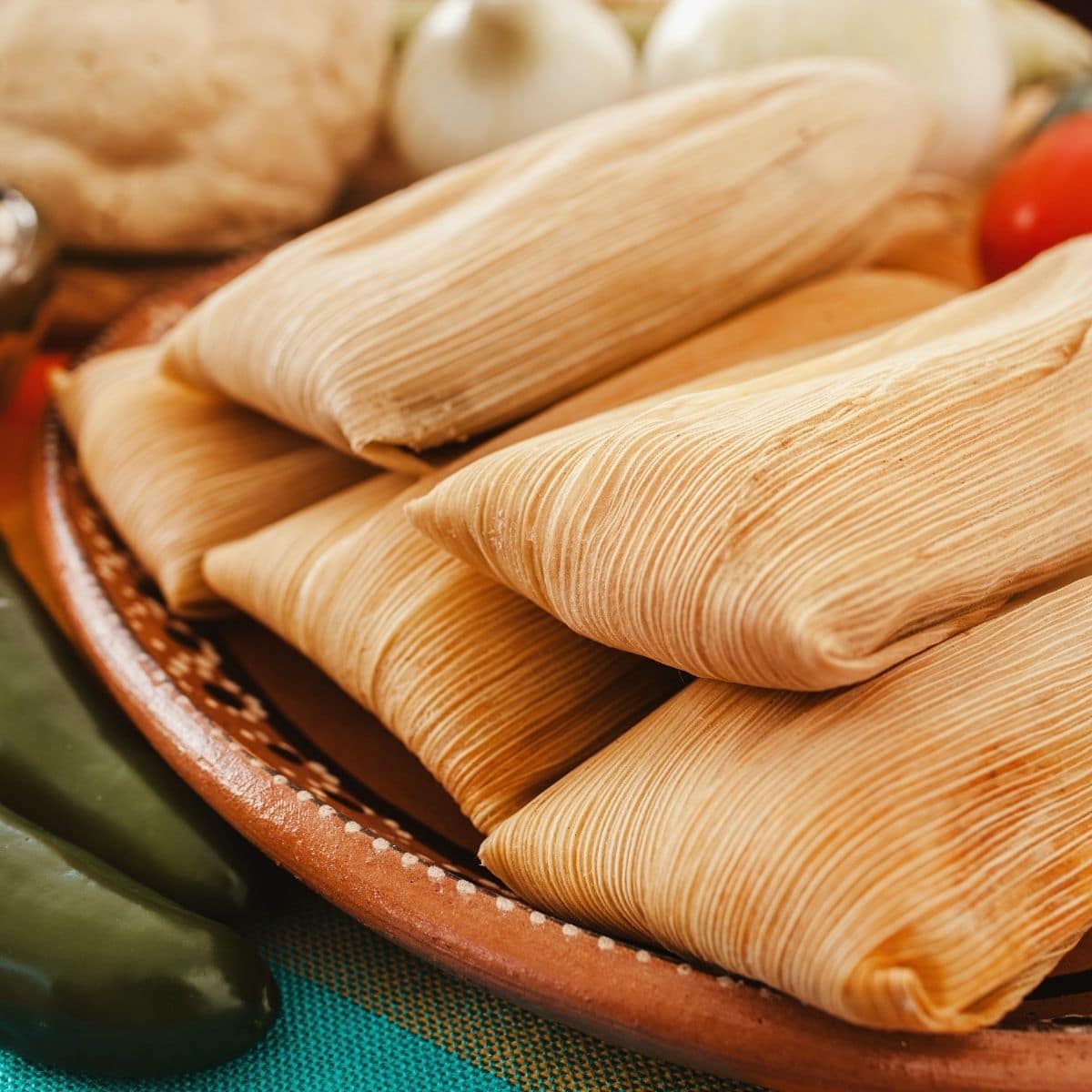 Square image of a plate full of tamales.