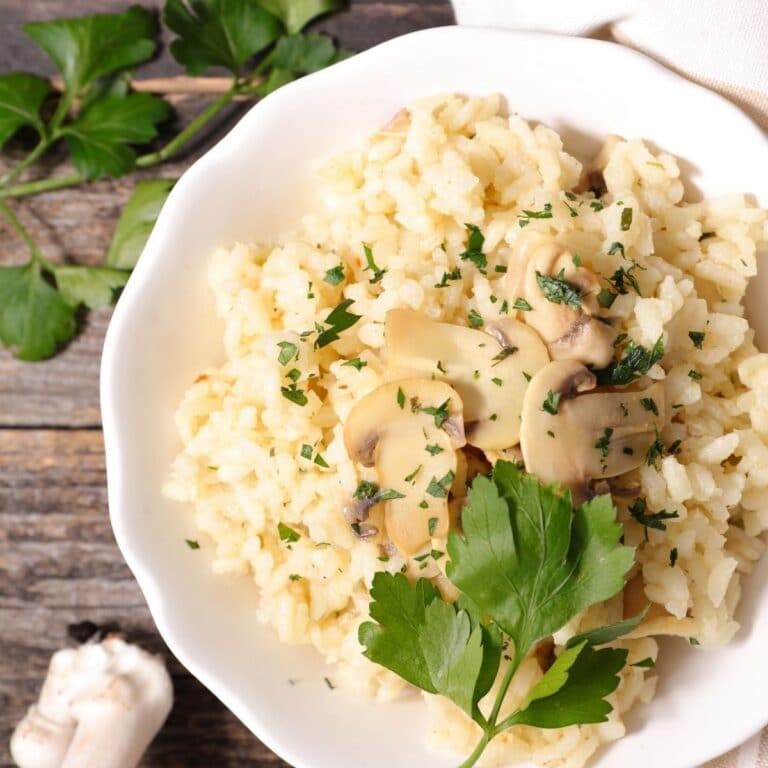 Square image of a white plate with risotto on it.