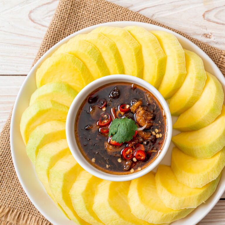 Square overhead of fish sauce substitute served with sliced mango.